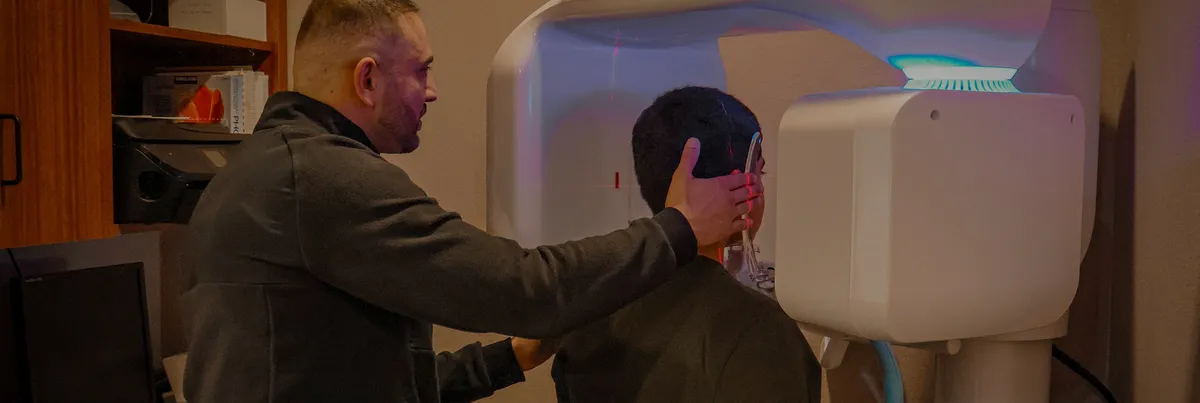 Dr. Ishaya positioning a patient in the office 3D cone beam CT scanner